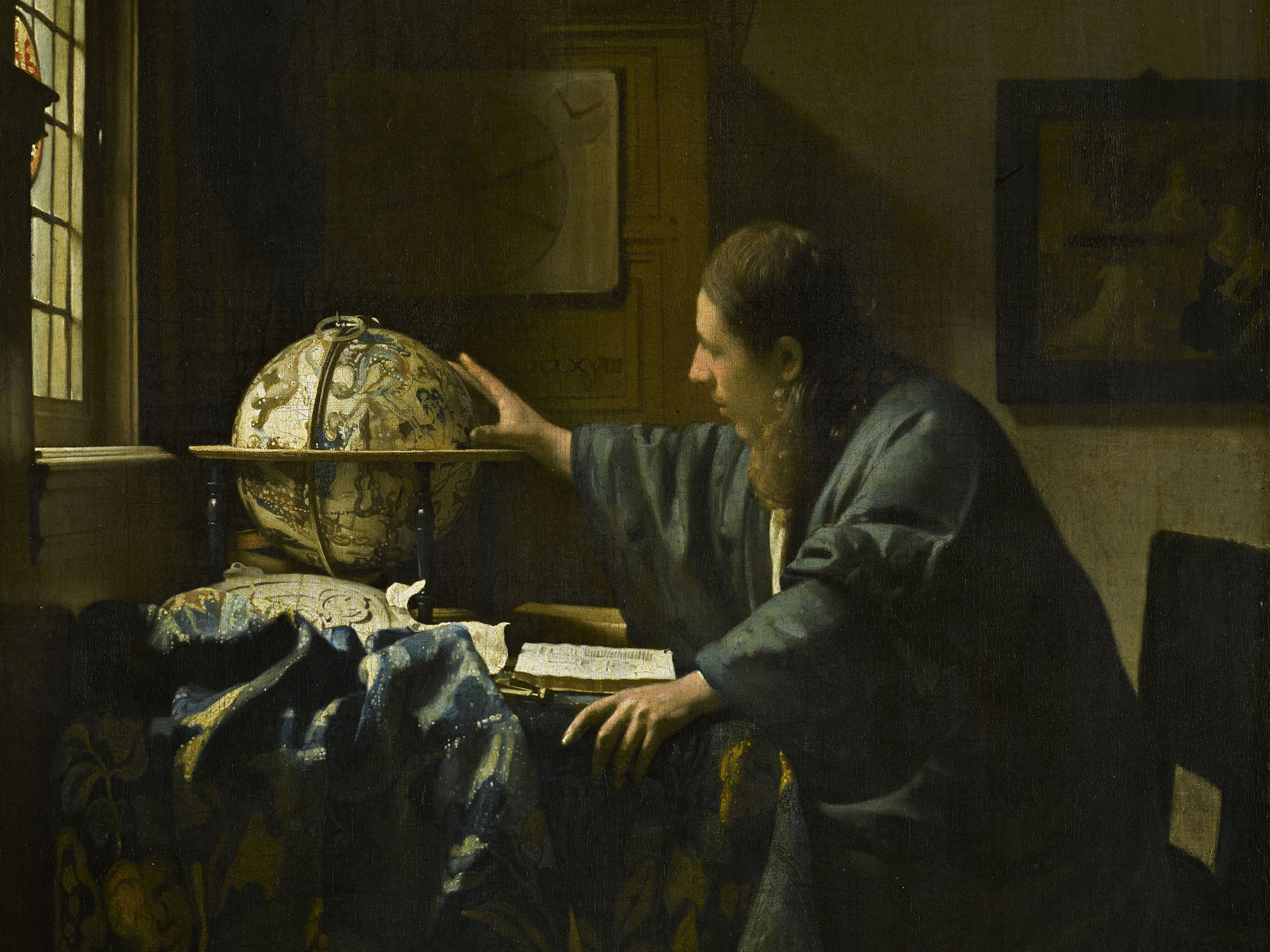 An astronomer reaches towards a celestial globe beside an open book in Johannes Vermeer's painting.